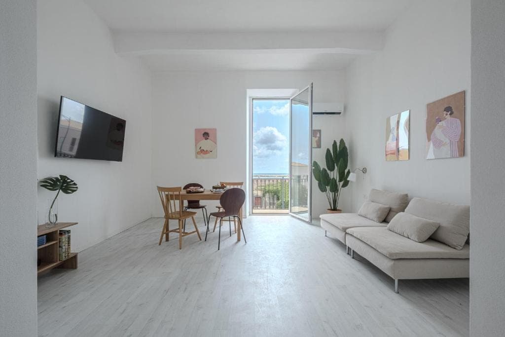 The living room with television, table and the glazed door onto the balcony